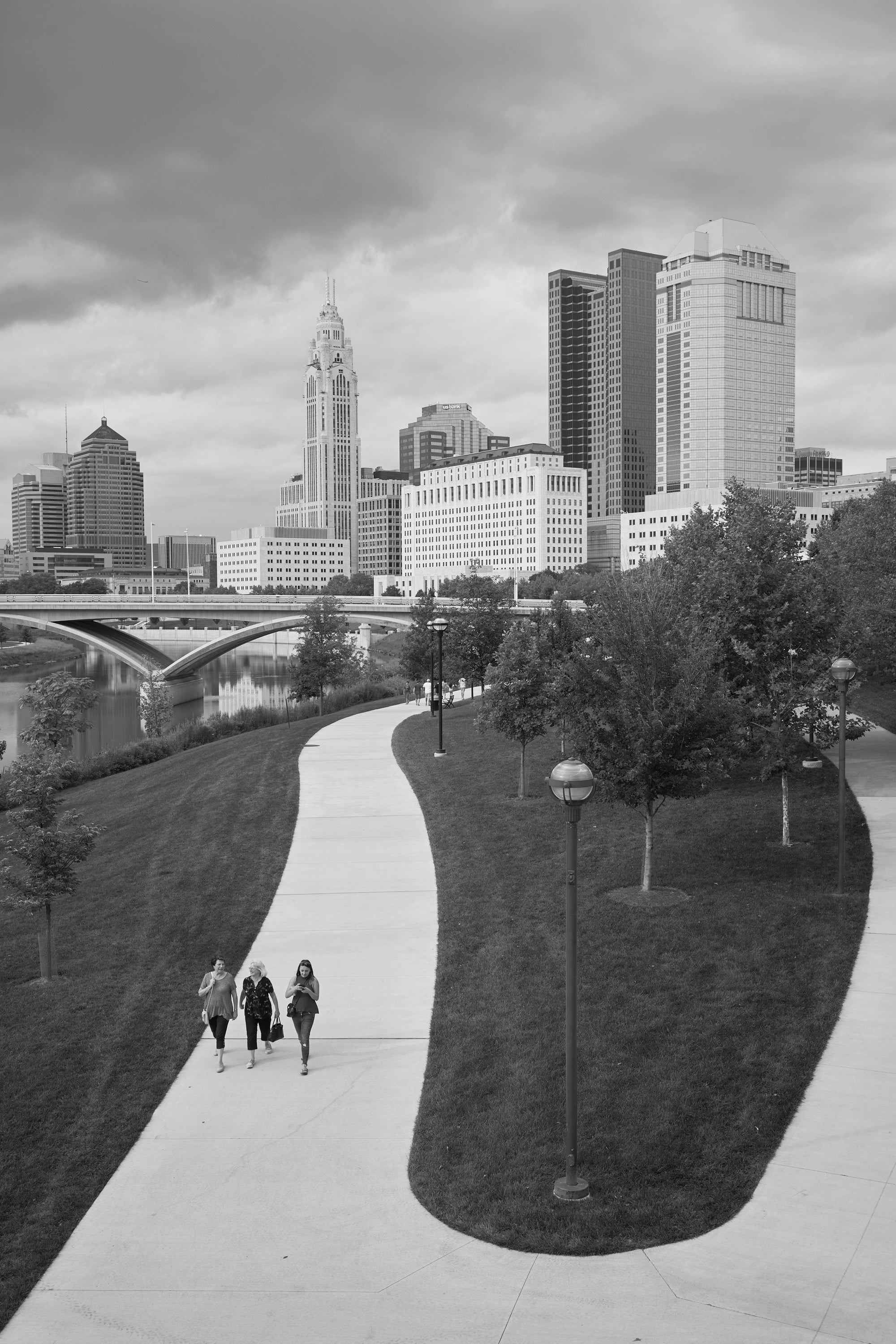 Downtown Columbus OH Ccty skyline with Scioto river and people walking on a path