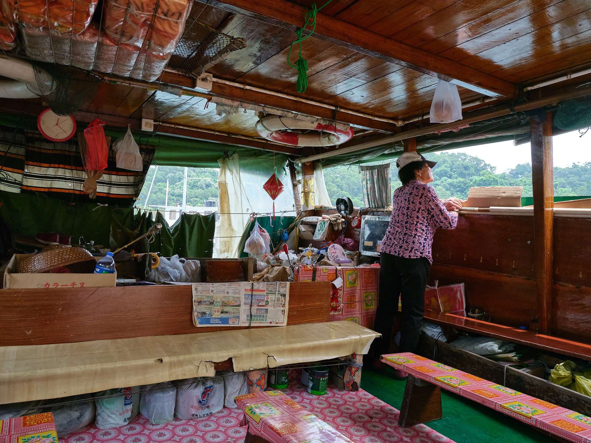 Ferry captain standing with various food items and packaging visible in the background.