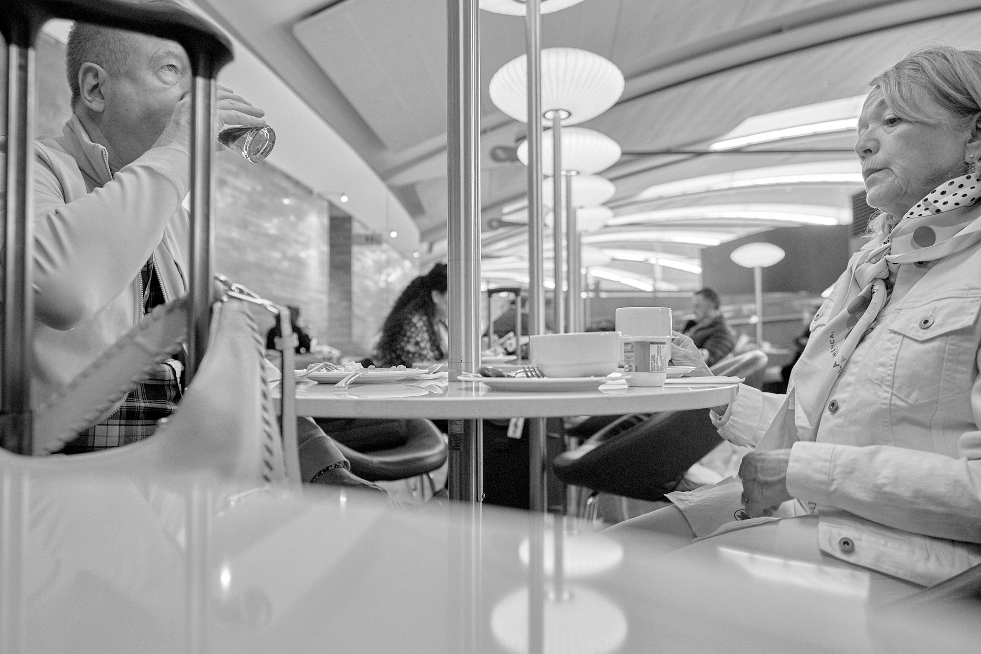 A image of two travelers seated in an airport terminal during a layover.