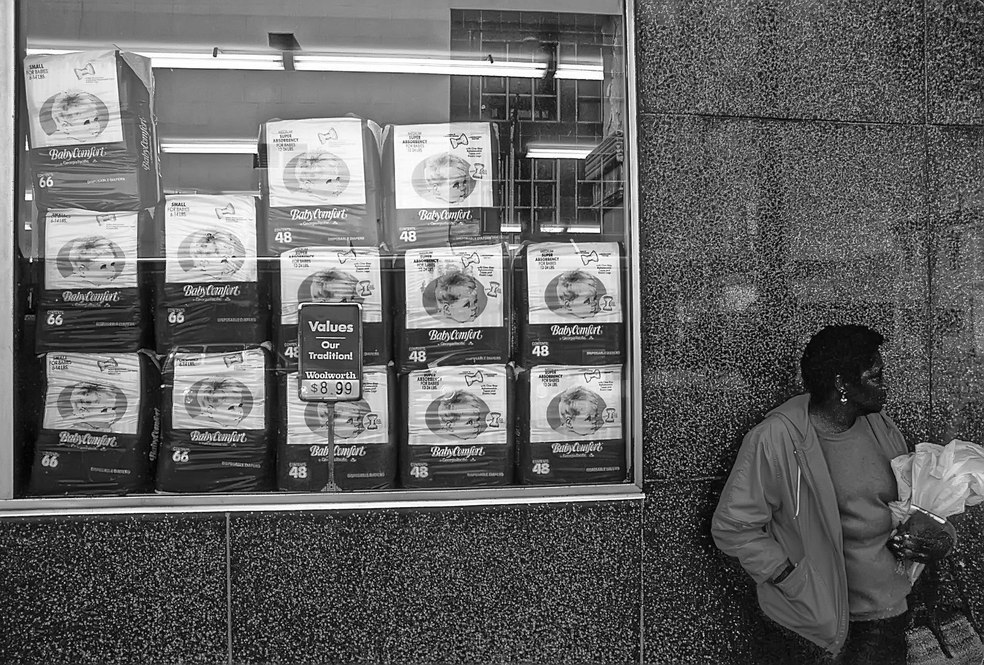 A person standing in front of a store window in Savannah GA, waiting.